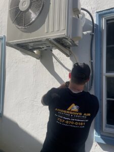 An HVAC technician installing an outdoor mini-split unit for Anderson's Air in Newport News, VA