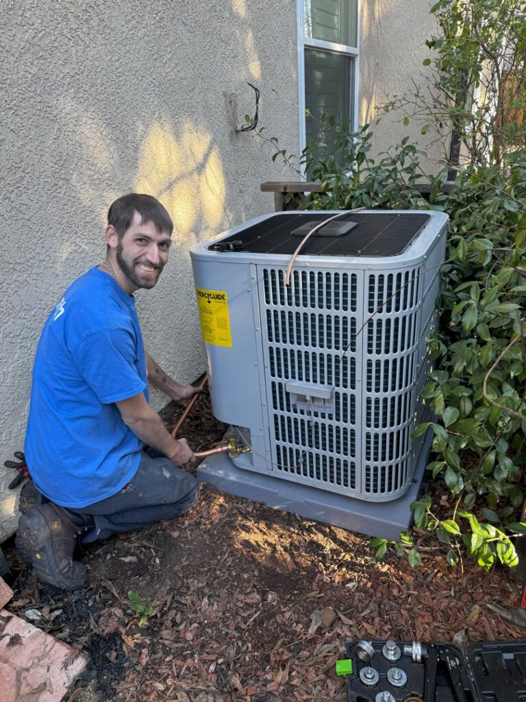An Airmech Heating and Air Conditioning technician installing an outdoor air conditioning unit in Elk Grove, CA.