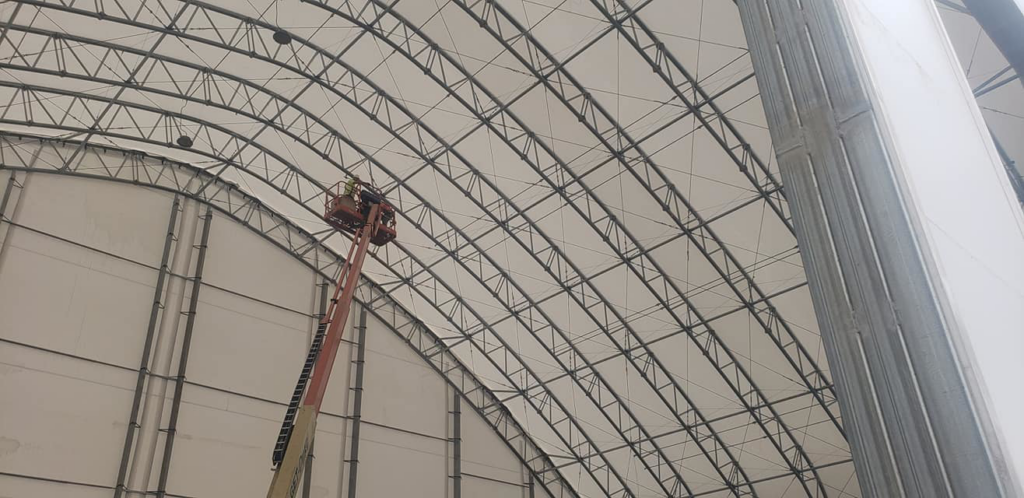 An HVAC technician in a boom lift installing overhead systems for Ray Martin Company of Omaha, NE