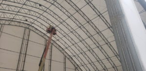An HVAC technician in a boom lift installing overhead systems for Ray Martin Company of Omaha, NE