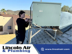 A Lincoln Air & Plumbing technician installing or servicing a large rooftop HVAC unit on a residential roof in Phoenix, AZ