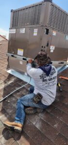 An HVAC technician installing a new rooftop unit for One Way Heating And Cooling, LLC in Horizon City, TX.