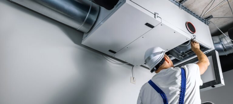 An HVAC technician installing an overhead ventilation system for General Air Conditioning Service Corp in Greenville, SC.