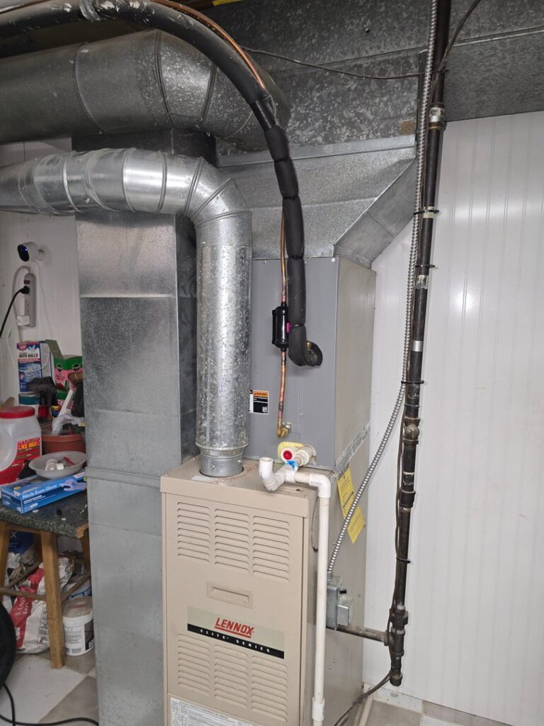 An HVAC technician performing maintenance on an outdoor air conditioning unit with tools for 24/7 Heating & Air, LLC in Grand Island, NE.