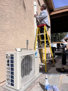 An HVAC technician installing a mini-split system for Dakine Heating & Cooling, LLC in Las Vegas, NV.