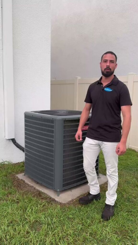 An HVAC technician from Air Support Cooling and Heating, LLC standing next to a newly installed outdoor AC unit in Tampa, FL