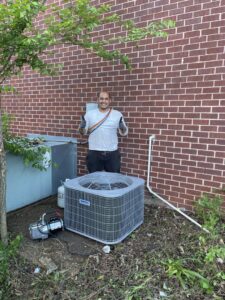 An HVAC technician from KMC Heating and Cooling LLC giving a thumbs up next to a newly installed Tempstar AC unit in Clarksville, TN.