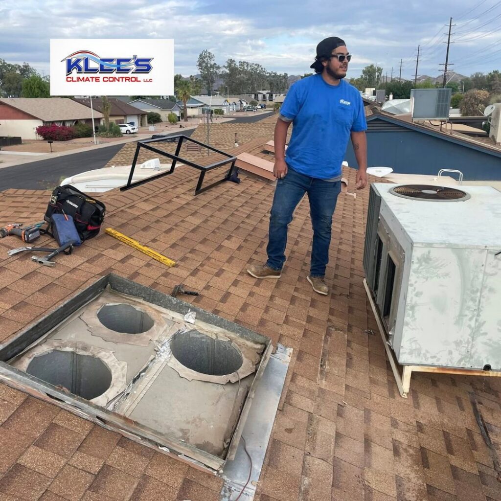 An HVAC technician on a residential roof during an HVAC unit replacement by Klee's Climate Control in Mesa, AZ.