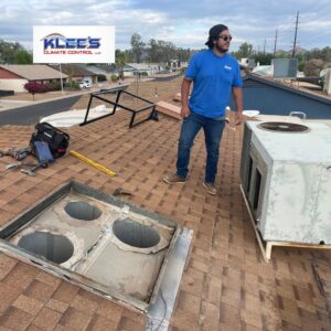 An HVAC technician on a residential roof during an HVAC unit replacement by Klee's Climate Control in Mesa, AZ.