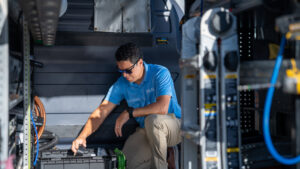 An HVAC technician organizing tools and parts inside a service van for Blue Air Heating and Cooling in Orlando, FL.