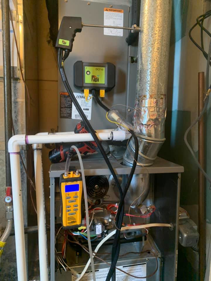 An HVAC technician performing diagnostics on a furnace with specialized tools at 413 Services in Piedmont, SD