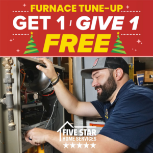 An HVAC technician from Five Star Heating & Cooling Group performing a furnace tune-up in Dayton, OH.