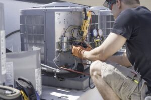 An HVAC technician performing maintenance on an outdoor air conditioning unit for Boykin Air Conditioning Services in Sumter, SC.