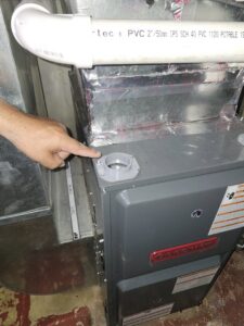 An HVAC technician pointing at a component on a Goodman furnace unit during service by Giant HVAC in Chicago, IL