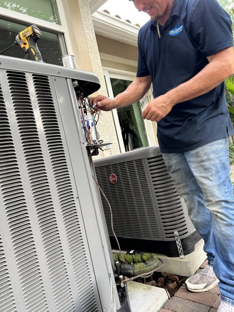 An HVAC technician from Air Support Cooling and Heating, LLC repairing the electrical components of an outdoor AC unit in Tampa, FL
