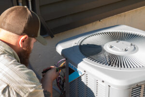 An HVAC technician repairing an outdoor air conditioning unit for Equality State Heating & Cooling in Casper, WY.
