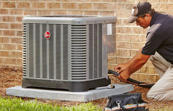 An HVAC technician repairing an outdoor air conditioning unit for Mike Watson Heating and Cooling in Wichita, KS.
