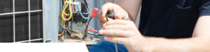 An HVAC technician repairing the electrical components of an outdoor AC unit for Thrasher Service Corp in Des Moines, IA.