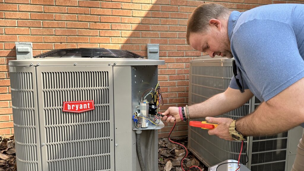 An HVAC technician repairing the electrical components of a Bryant outdoor AC unit for Stoudenmire Heating & Air Conditioning in Columbia, SC.
