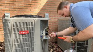 An HVAC technician repairing the electrical components of a Bryant outdoor AC unit for Stoudenmire Heating & Air Conditioning in Columbia, SC.