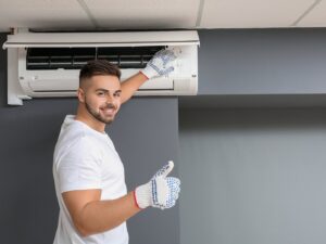 An HVAC technician repairing a ceiling-mounted AC unit for ChillTek AC Repair Glendale in Glendale, AZ.