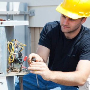 An HVAC technician repairing an outdoor condenser unit for Bart Fey HVAC and Plumbing LLC in West Jefferson, OH.
