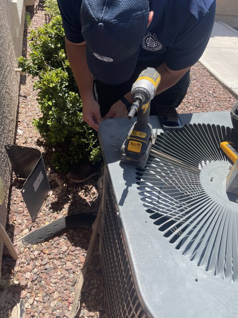 An HVAC technician from Blue Collar HVAC in Las Vegas, NV, repairing an outdoor condenser unit.