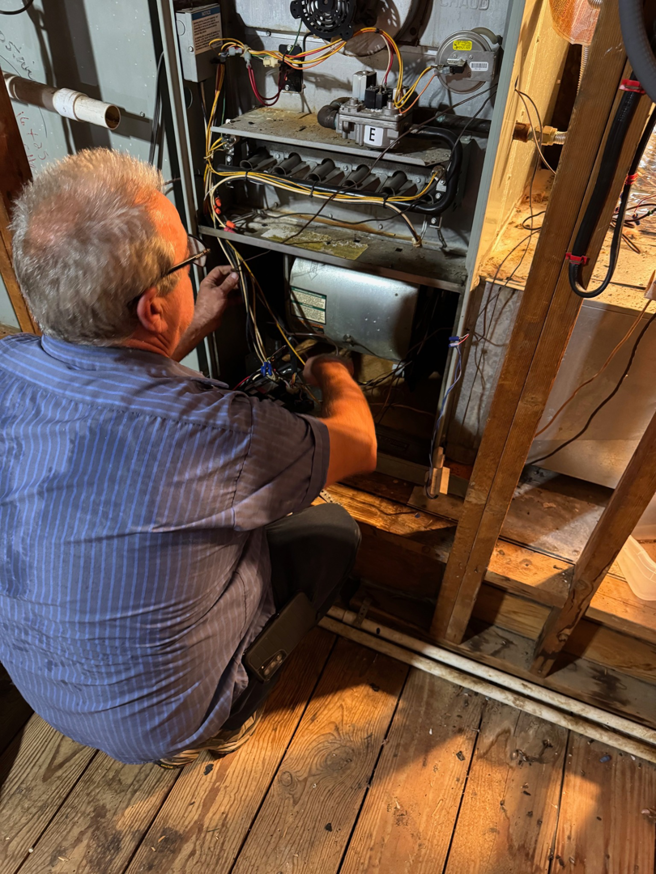 An HVAC technician repairing an indoor furnace unit for Best Air Conditioning & Heating, Co. in Memphis, TN.
