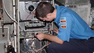 An HVAC technician performing repair and maintenance work on a furnace unit for ColemanAir, LLC in Horn Lake, MS