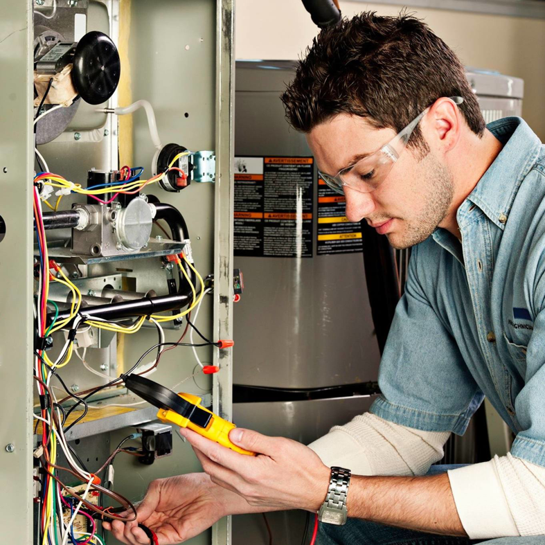 An HVAC technician repairing furnace wiring with a multimeter at Climate Care Heating and Air in Williston, ND