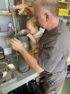 An HVAC technician from Vintage Heating LLC repairing a heating unit in Ketchikan, AK