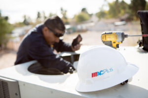 An HVAC technician repairing an outdoor air conditioning unit for AC Plus Heating & Air Conditioning Service in Las Vegas, NV.