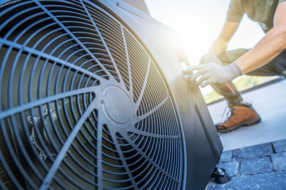 An HVAC technician performing repairs on an outdoor air conditioning unit for Avery Heating and Cooling in Independence, MO.