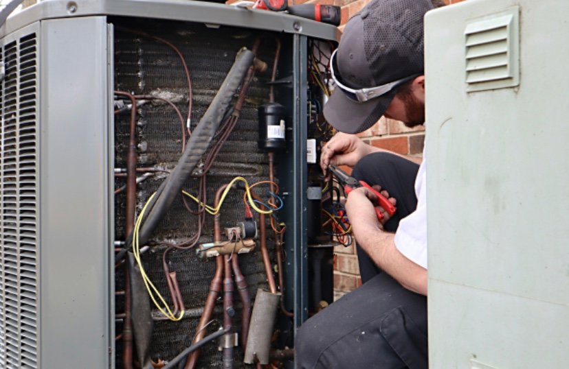 An HVAC technician repairing the internal components of an outdoor air conditioning unit for 5 Star Charleston Heating and Air in Charleston, SC.