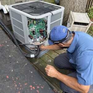 An HVAC technician from Deljo Heating, Cooling & Plumbing repairing the internal components of an outdoor AC unit in Chicago, IL.