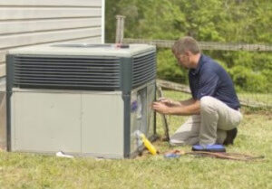 An HVAC technician performing repairs on an outdoor air conditioning unit for Comfort Zone of the Carolinas in Rock Hill, SC.