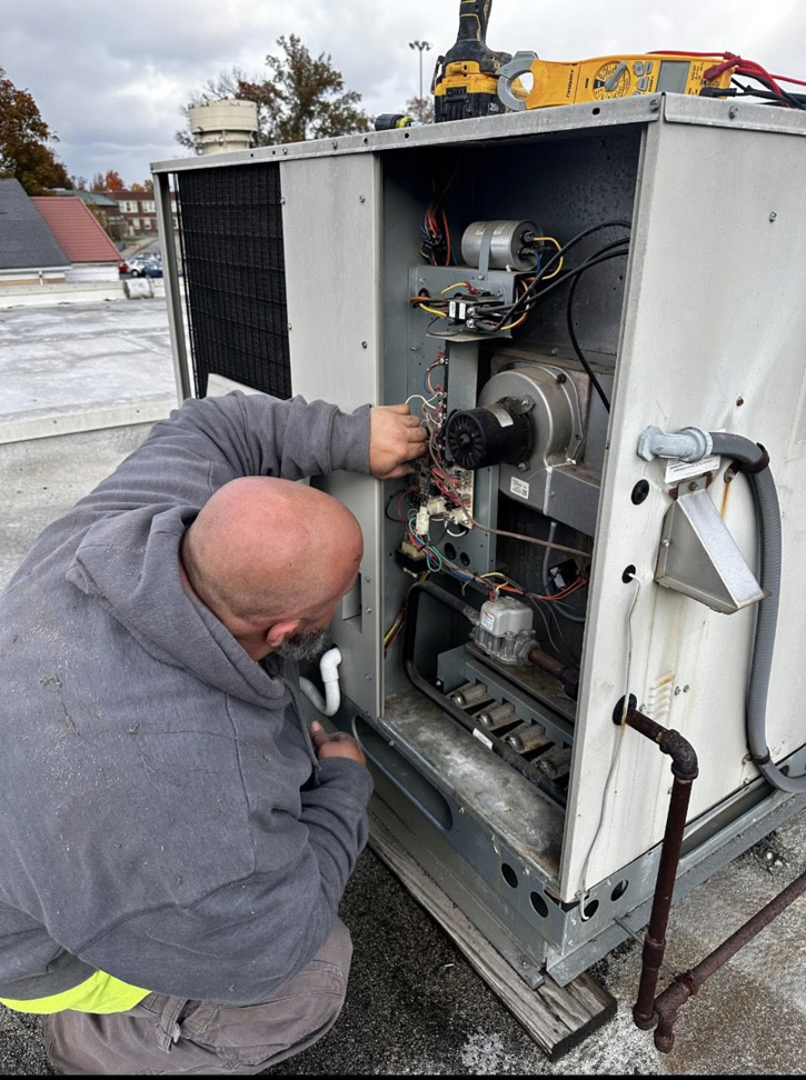 An HVAC technician repairing a commercial rooftop unit for Air Conditioning Experts in Orlando, FL.