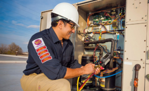 An HVAC technician repairing a commercial rooftop unit for AirTemp Heating & Cooling in Nashville, TN.