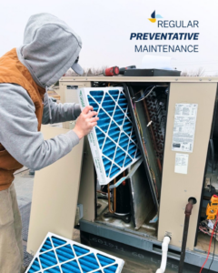An HVAC technician replacing an air filter on a rooftop unit during preventative maintenance by Climate Systems, Inc. in Sioux Falls, SD.