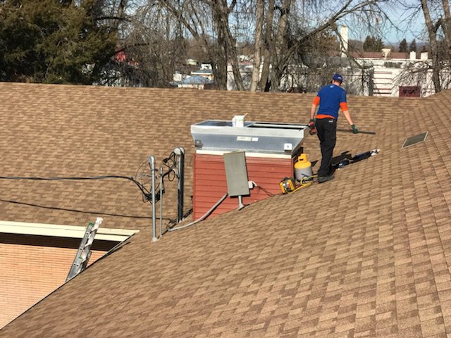 An HVAC technician performing service on a rooftop unit for Element Heating & Cooling, Inc. in Twin Falls, ID