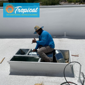 An HVAC technician from Tropical Companies working on a rooftop air conditioning unit in Chandler, AZ
