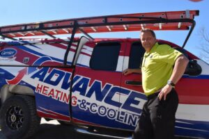 An Advanced HVAC and Plumbing technician standing next to a company service truck in Morgantown, WV.