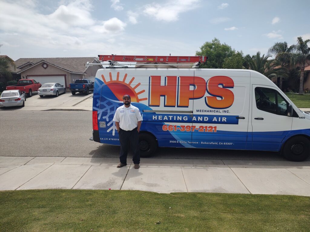 An HVAC technician standing next to a branded service van for HPS Plumbing Services Bakersfield, CA.