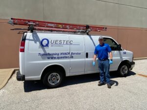 An HVAC technician standing proudly next to a QuesTec branded service van with a ladder in Columbia, MO