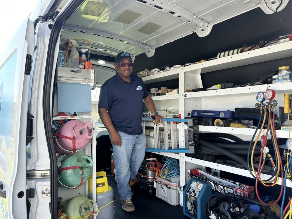 An HVAC technician standing inside a fully equipped service van with tools and parts from Reliable Heating and Air LLC in Summerville, SC.