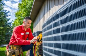 An Advanced Home Services technician performing maintenance on an outdoor AC condenser unit in Rigby, ID.