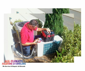 An HVAC technician servicing an outdoor air conditioning unit at All Climate Heating & Cooling in Redmond, WA