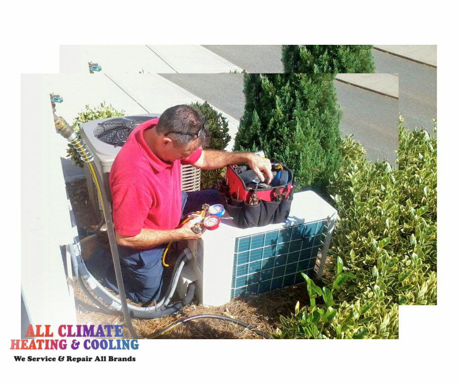 An HVAC technician servicing an outdoor air conditioning unit at All Climate Heating & Cooling in Redmond, WA