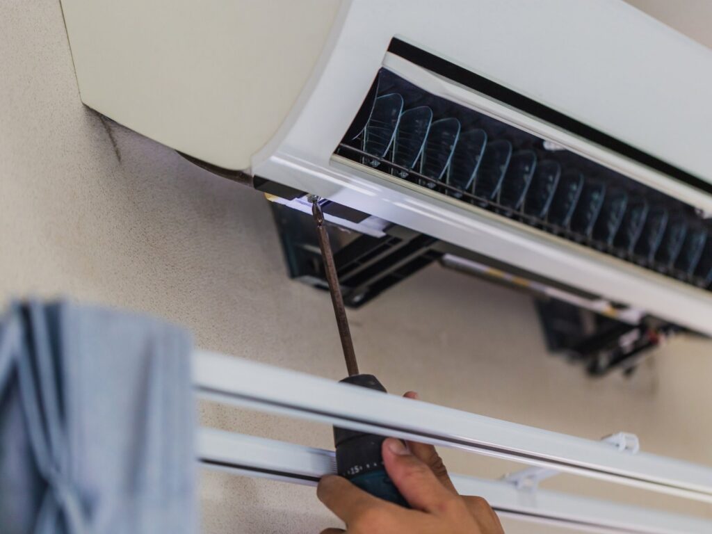 An HVAC technician in a cap and vest servicing an AC unit for ChillTek AC Repair Glendale in Glendale, AZ.
