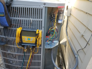 An HVAC technician servicing an outdoor air conditioning unit with diagnostic tools at Comfort Zone A/C & Heating, LLC in Kenner, LA.